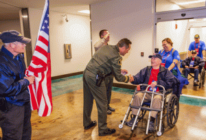 Photo of Sheriff Ian Parkinson greating the Honor Flight honorees